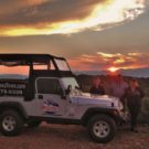 tourists outside jeep enjoying the sunset over the mountains during a Colorado Jeep Tour