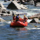 two guests and guide enjoying whitewater rafting trip