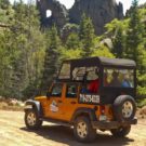 guests driving down dirt road on sunny day during Colorado Jeep Tour