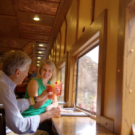 couple sitting in club car, sharing a drink, enjoying the view