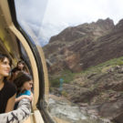 Family looking out Royal Gorge train admiring mountain scenery