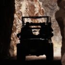 silhouette view of jeep driving through tunnel